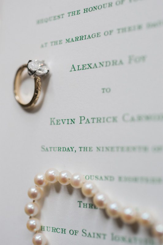 A close shot of the wedding ring and invitation card