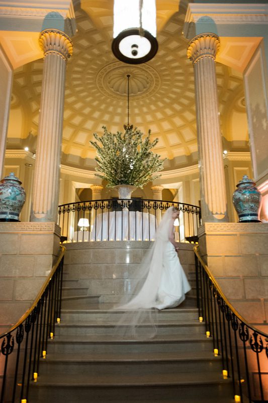 The bride walks up a beautifully decorated flight of stairs