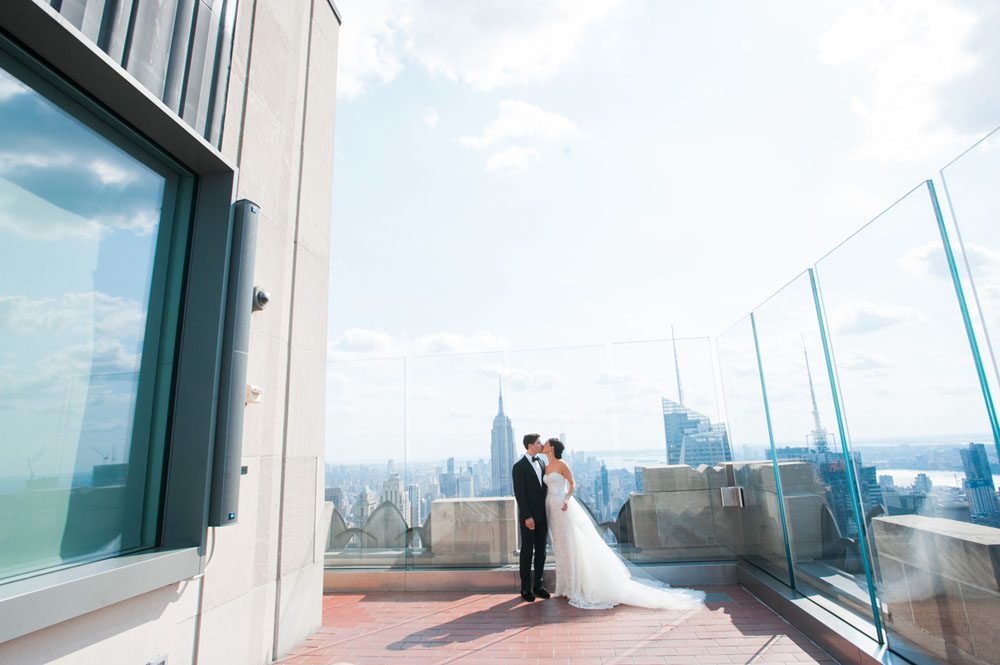 The bride and the groom kissing on the rooftop
