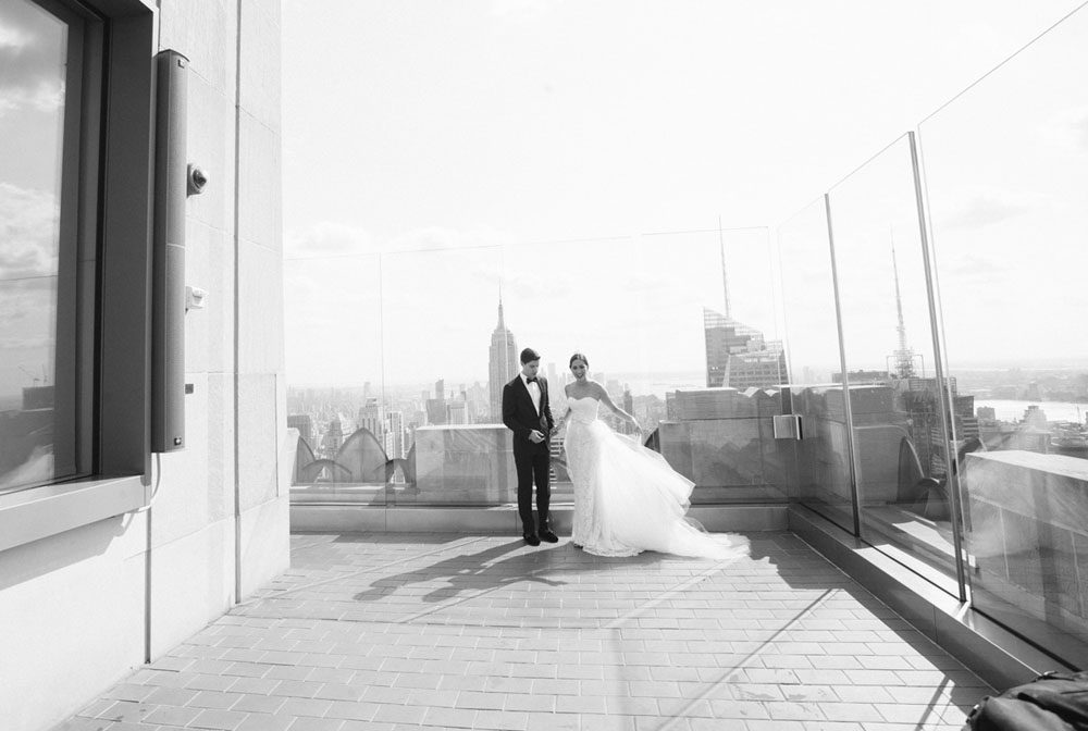 The bride and the groom walking on the hotel terrace