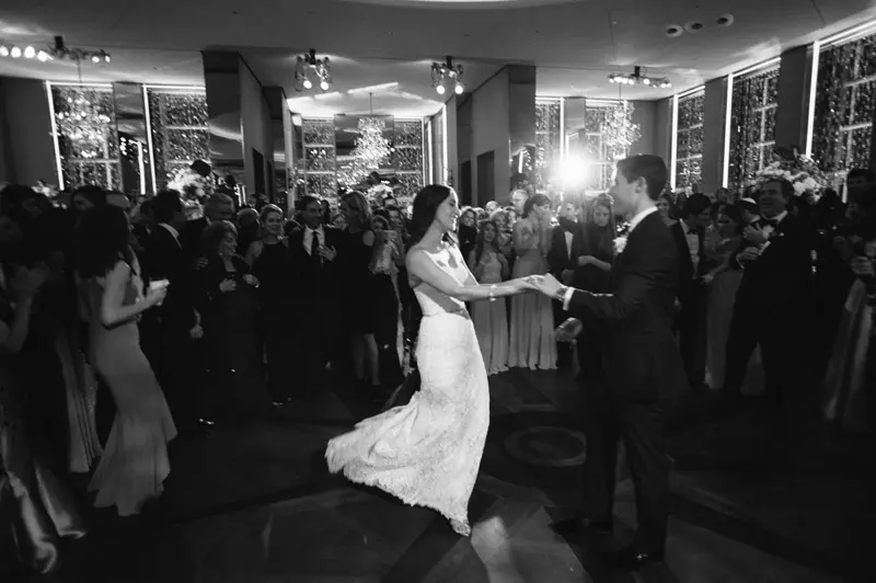 Guests cheer the bride and groom during their wedding dance