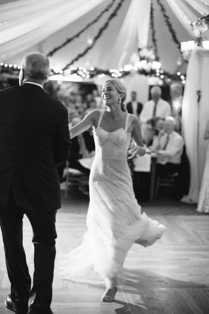 The bride is enjoying a dance with her father at the wedding