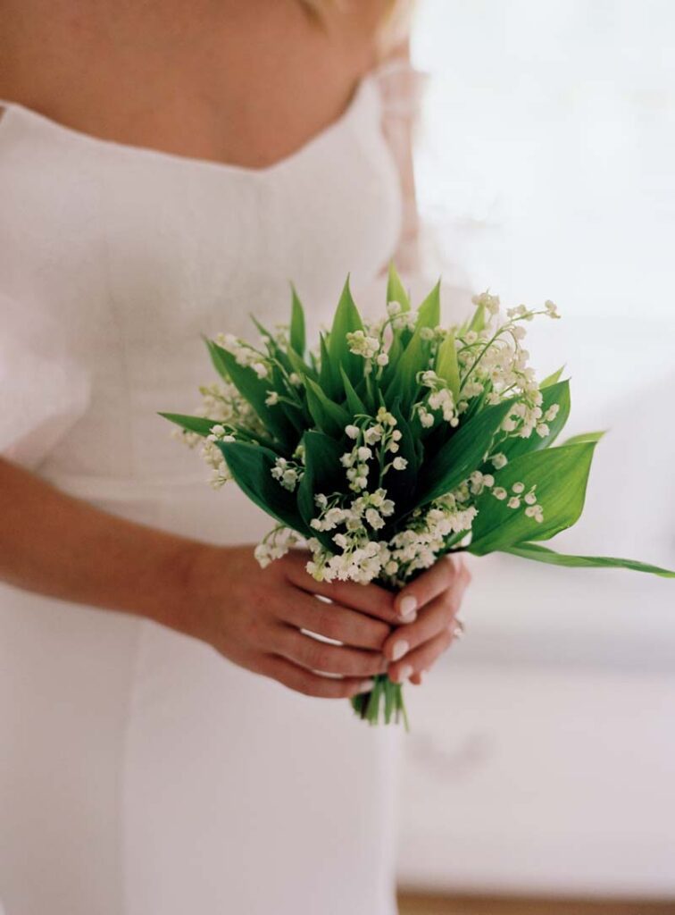 The bride holds on to a small bouquet of flowers