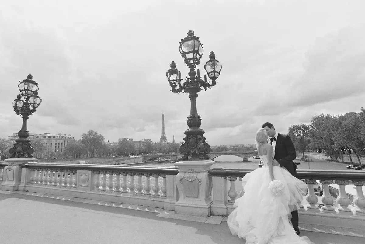 The bride and the groom kissing on a bridge