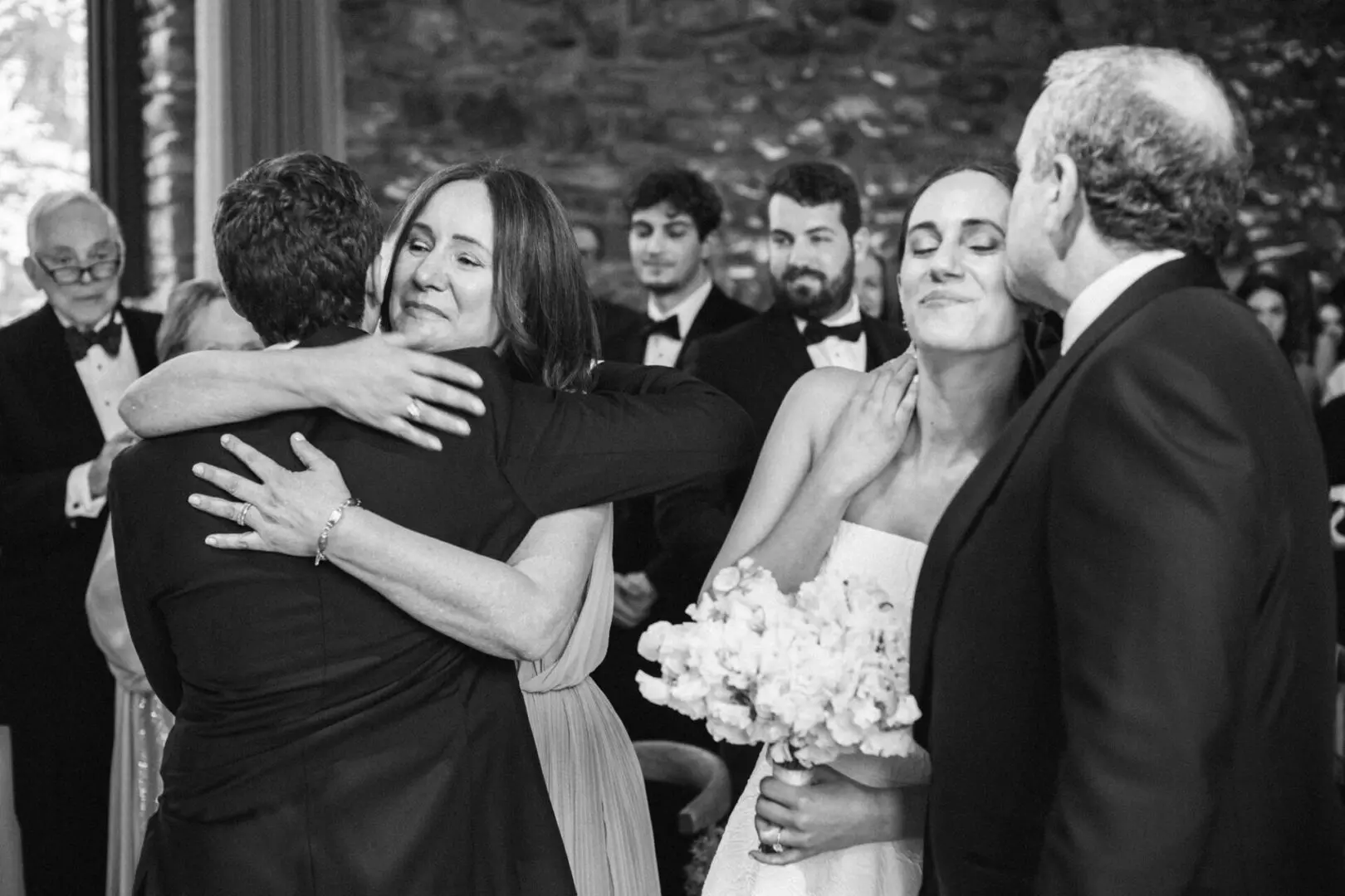The bride and the groom embrace as parents watch