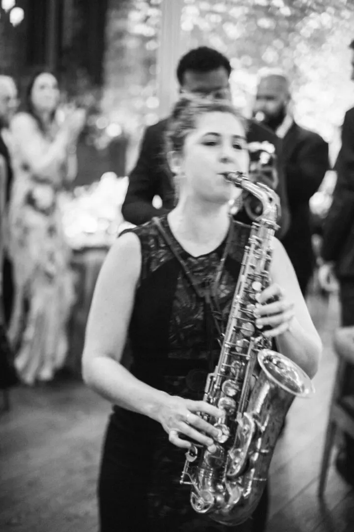 A lady is playing the saxophone at the event