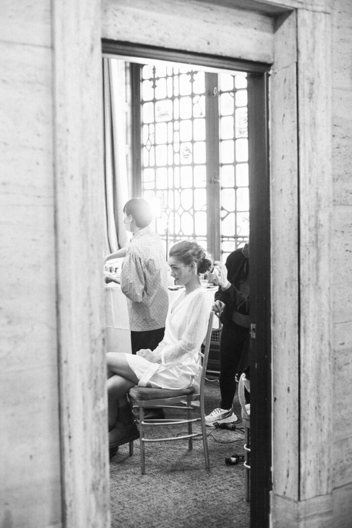 The bride sits while preparing for the wedding