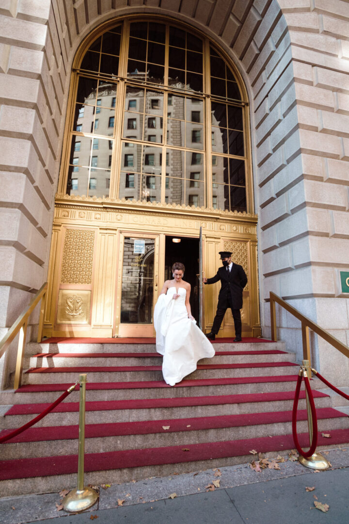 The bride steps down a flight of stairs onto the road