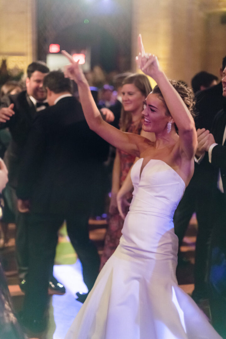 A picture of a bride dancing with her hands in the air