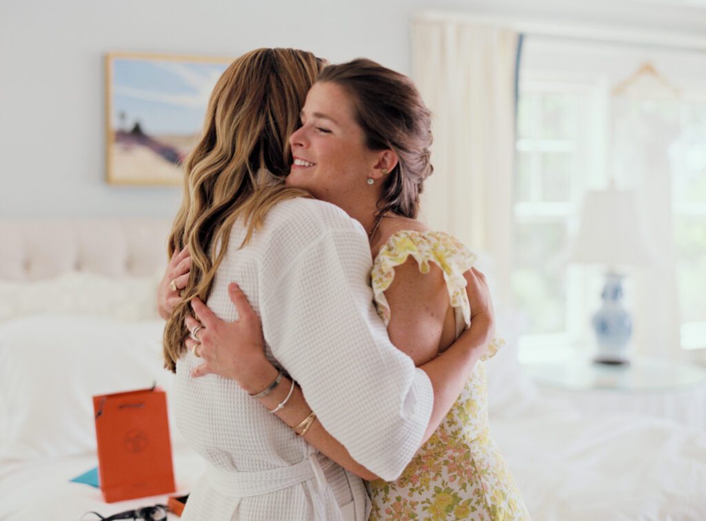 The bride gets a warm hug from a family member