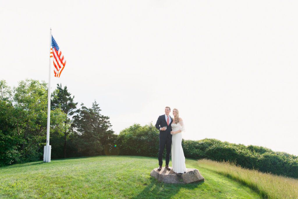 The bride and the groom pose near the American flag