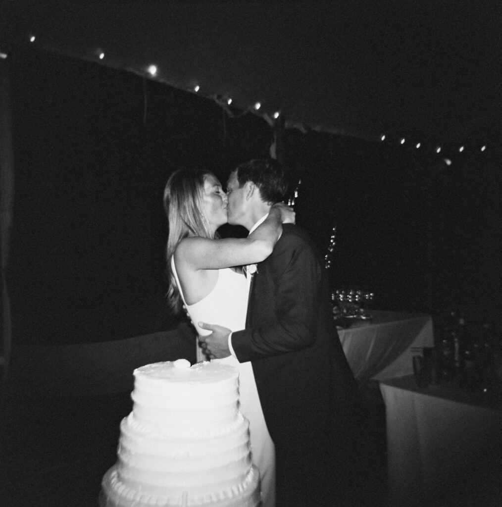 The bride and the groom kiss with the night sky as backdrop