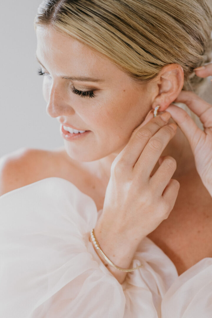 The bride wearing her earrings before the wedding
