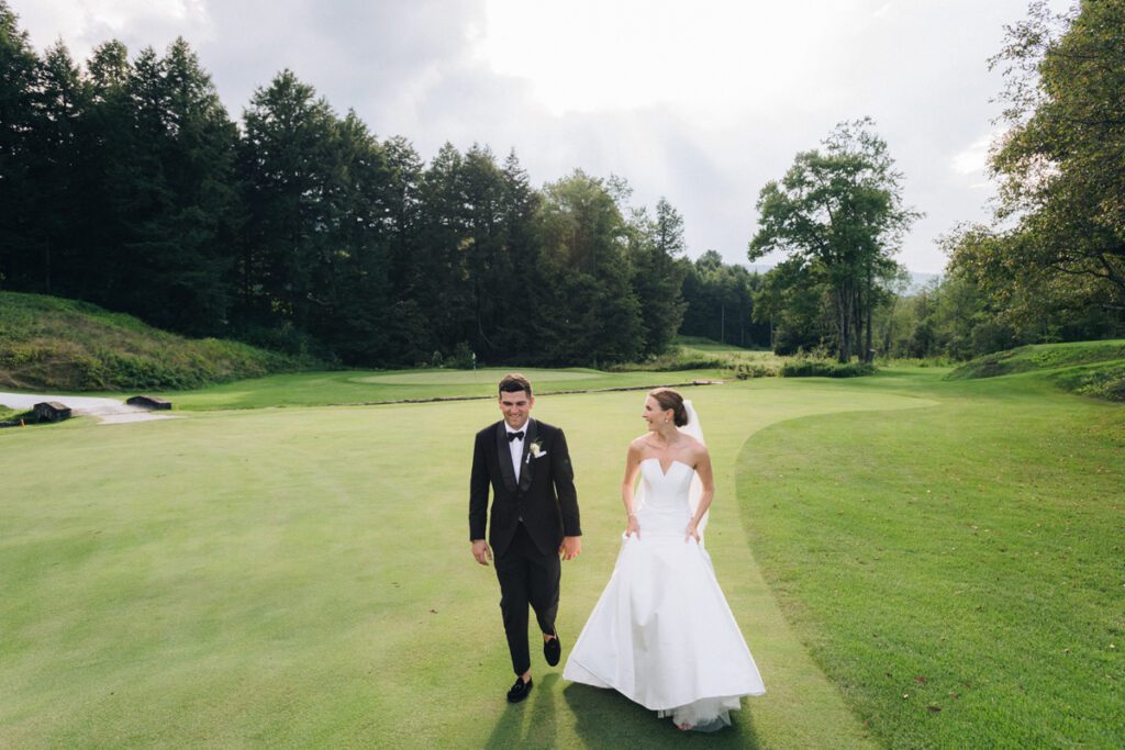 The bride and the groom walk in the green meadows
