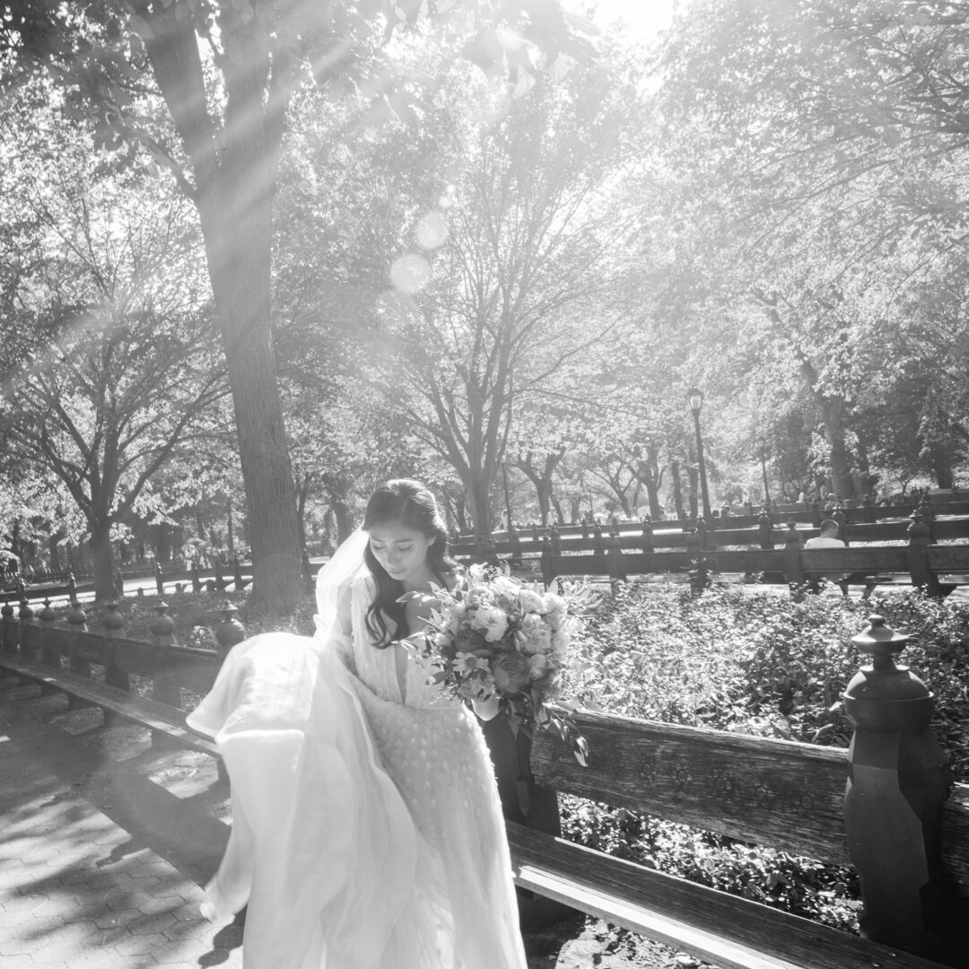 Bride standing near a fence at a park
