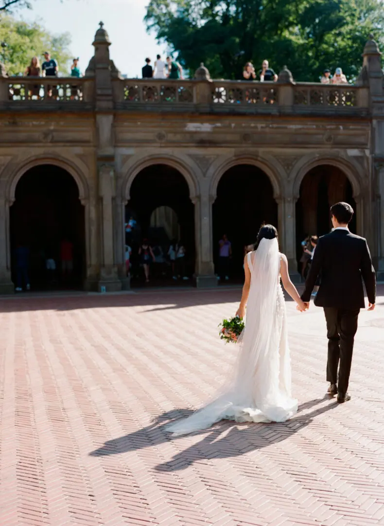 A newlywed couple walking in at the street