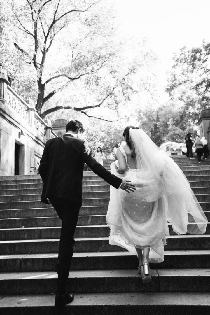 Bride and groom running up the stairs