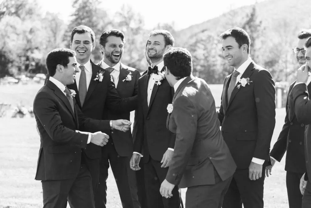 Groom standing and smiling with his friend group