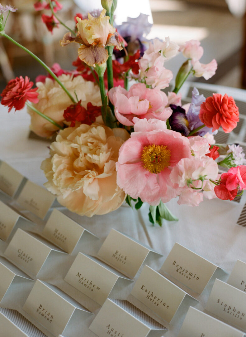 Table filled with flowers and cards with name
