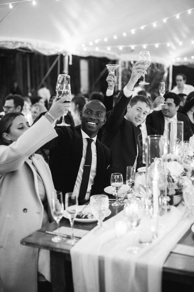 Men and a women holding wine glasses at the wedding