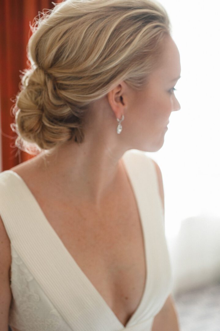 Side view of bride with hair bun and in white dress