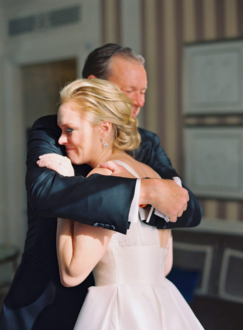 Father hugging his daughter who is in a wedding dress