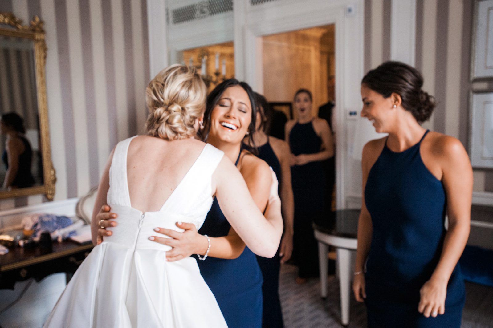 Bride hugging her friend with a group of women behind