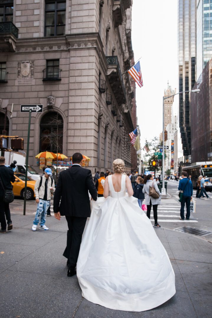Bride and groom in wedding dress walking on the road