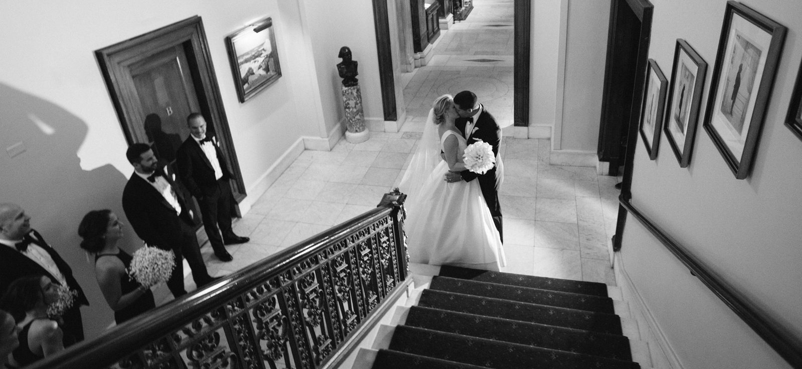 Bride and groom kissing near the staircase