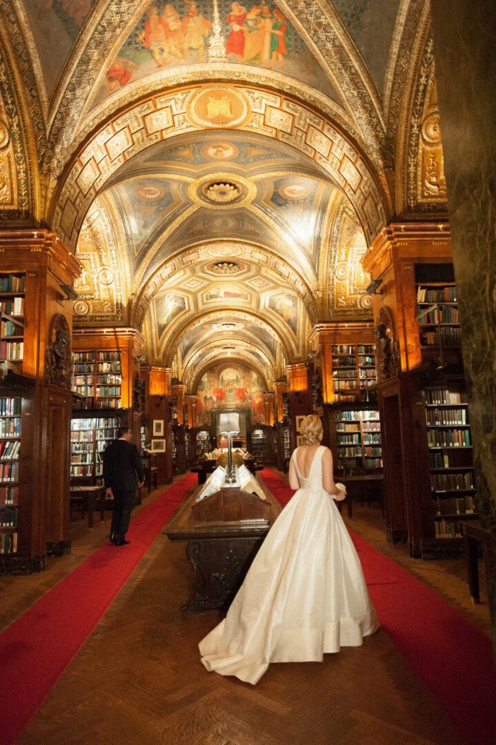 Bride and groom walking inside a library