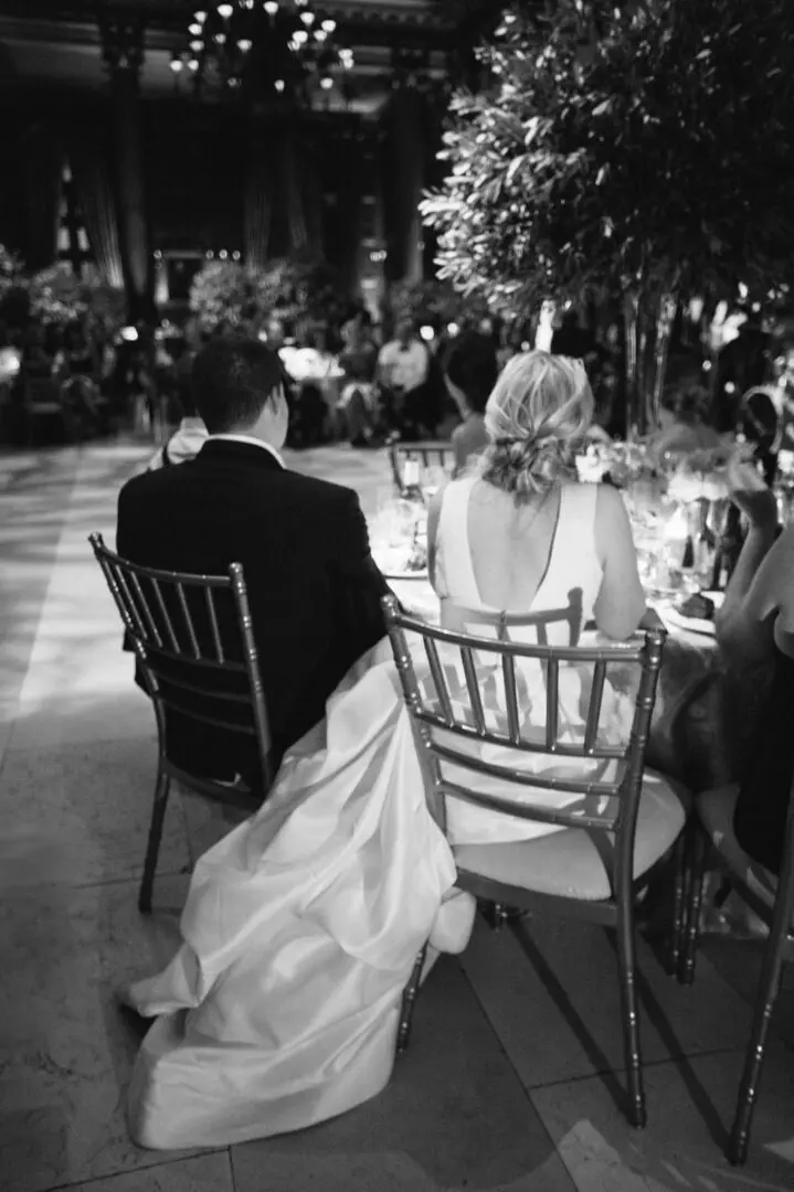 Bride and groom sitting in chairs under a tree