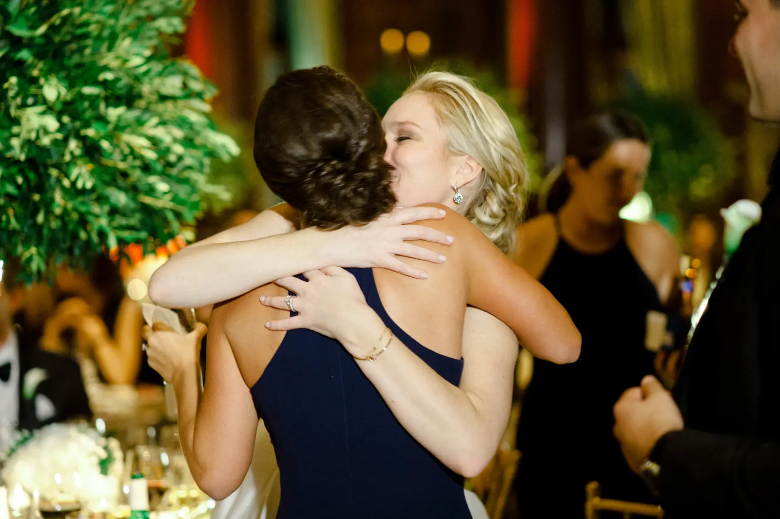 Two women hugging and kissing at the wedding