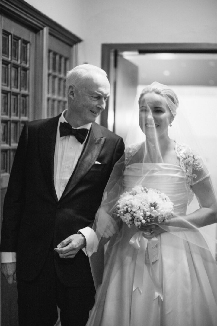 Black and white image of the bride with her father
