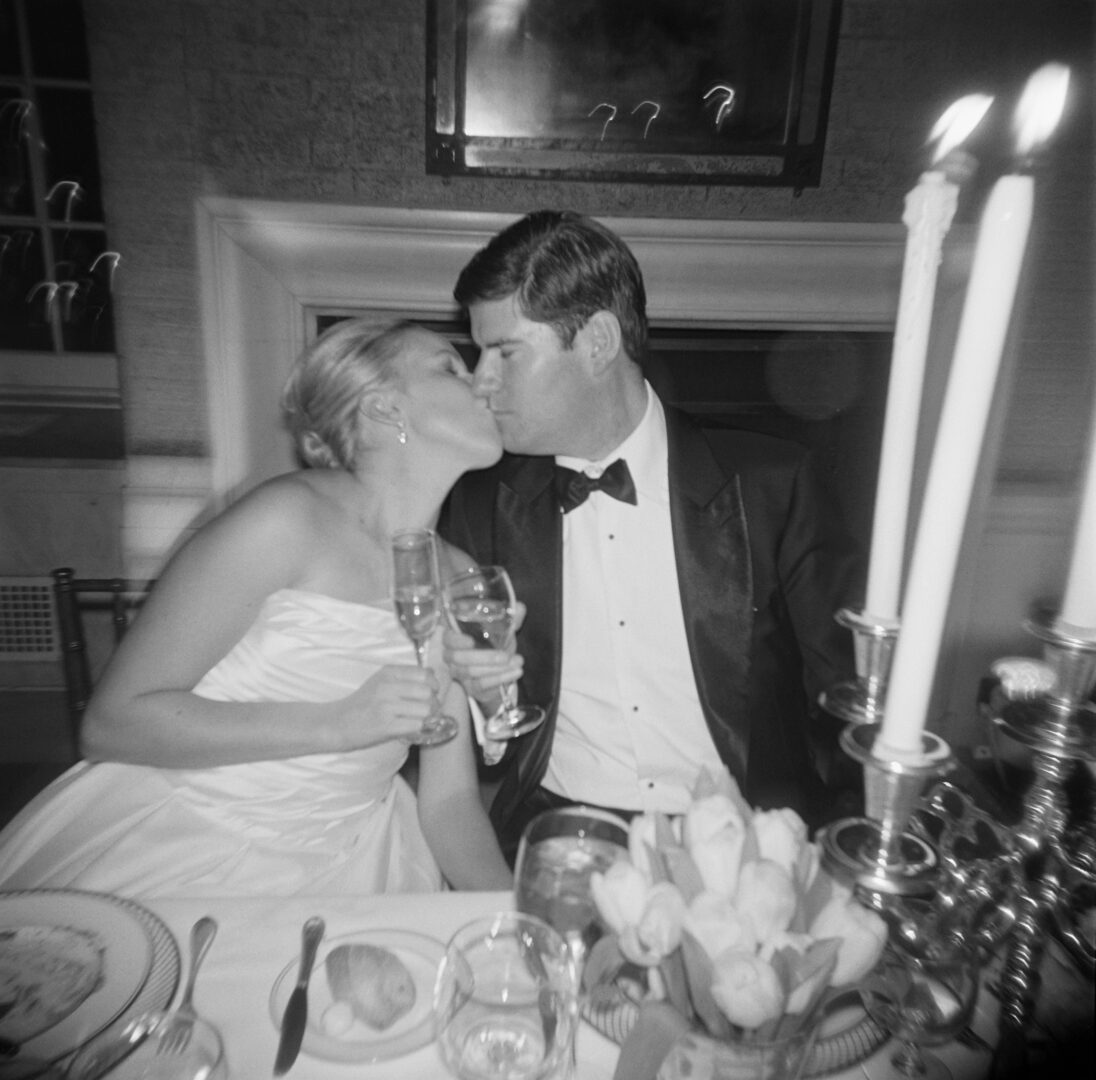 Black and white image of couple kissing and having Champaign