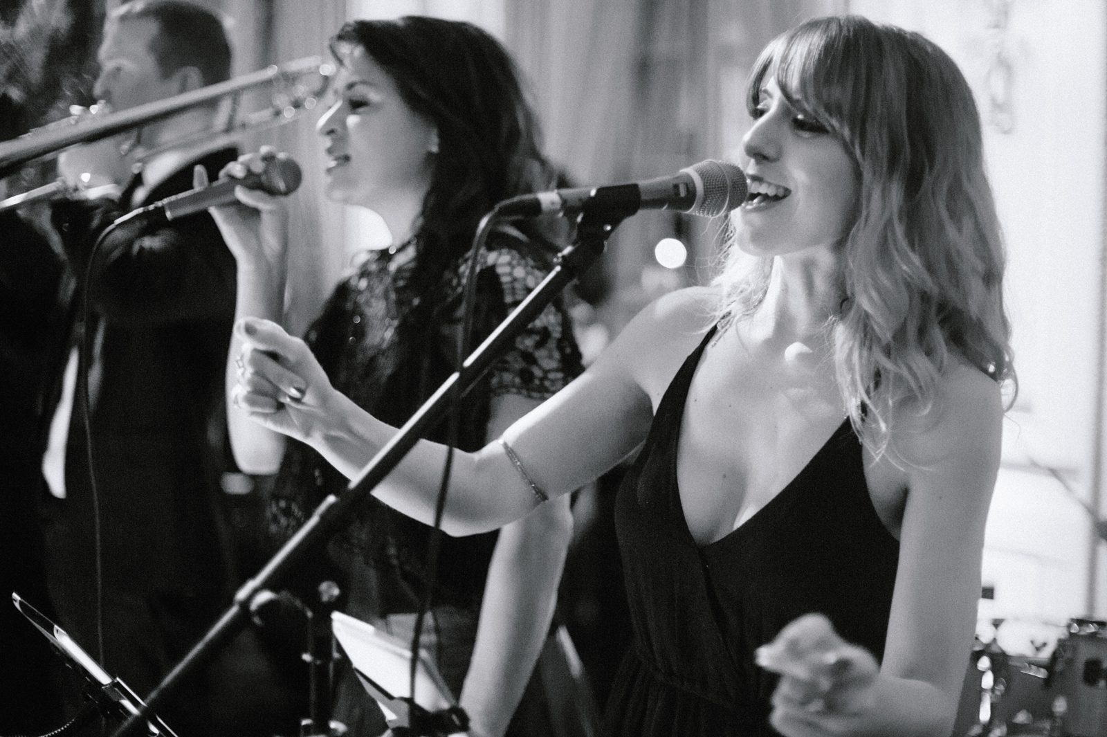 Black and white image of girls singing in the mic