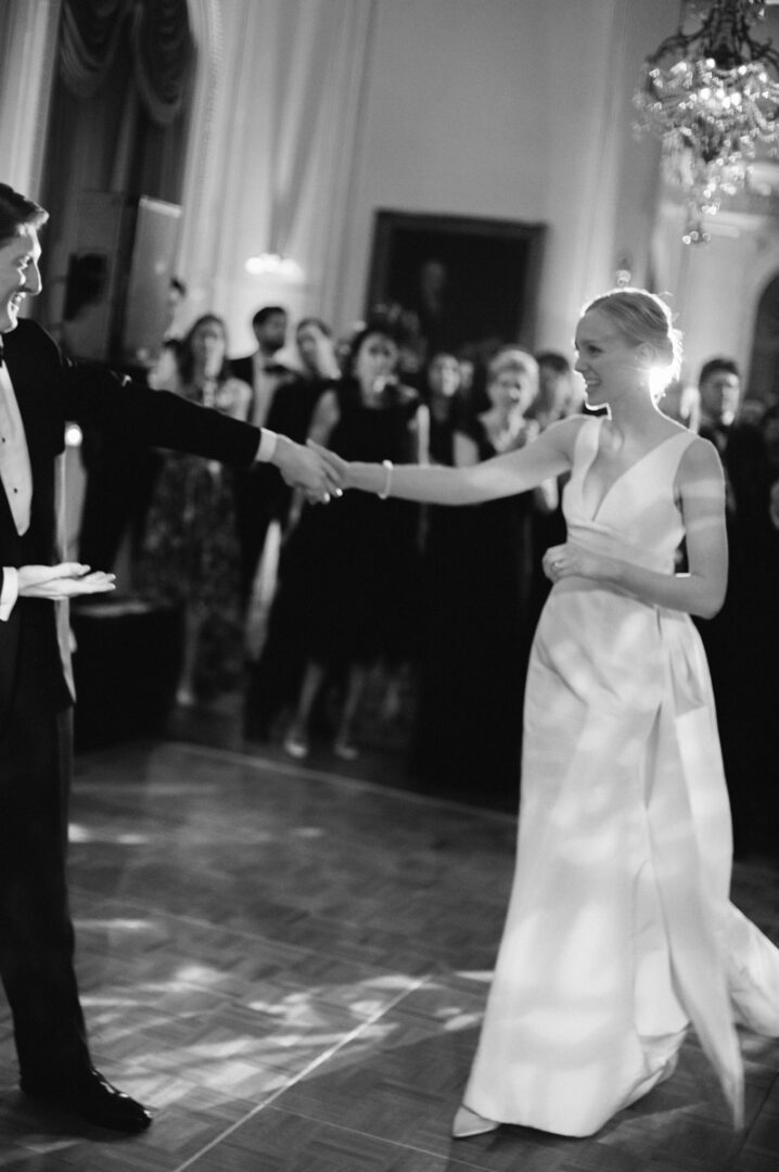 Black and white image of a couple dancing after a wedding