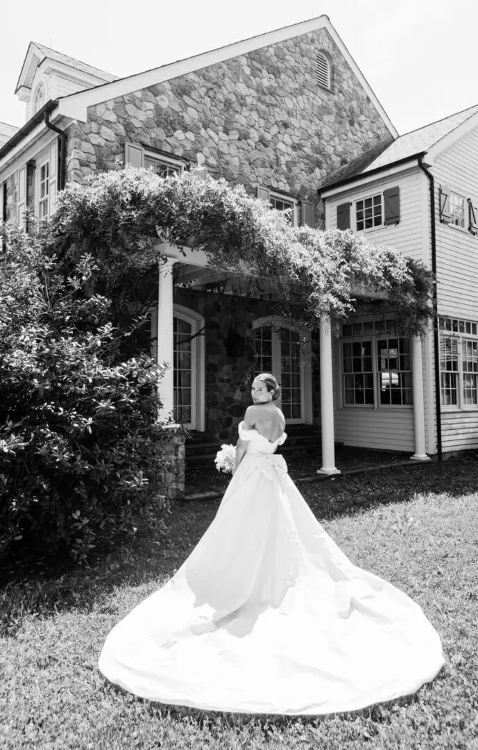 Black and white image of a bride outside a house