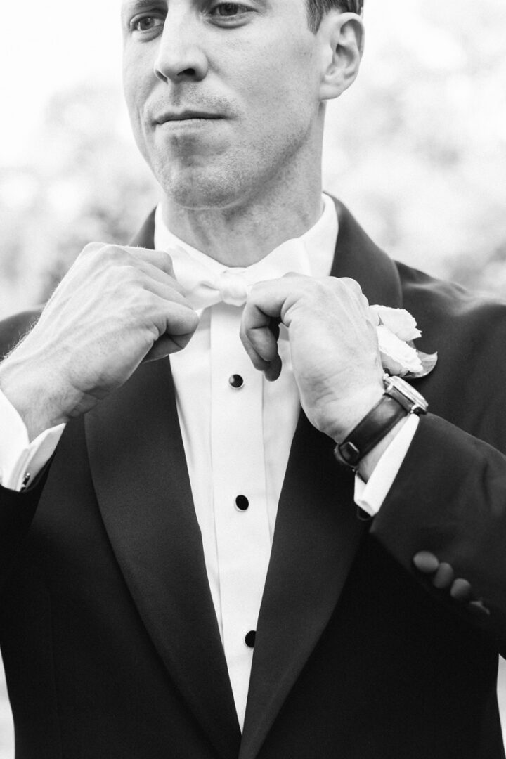 Black and white image of a groom posing at the camera