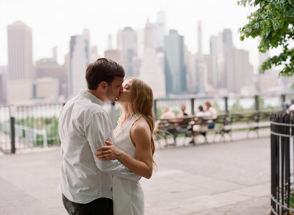 A couple kissing with a city background