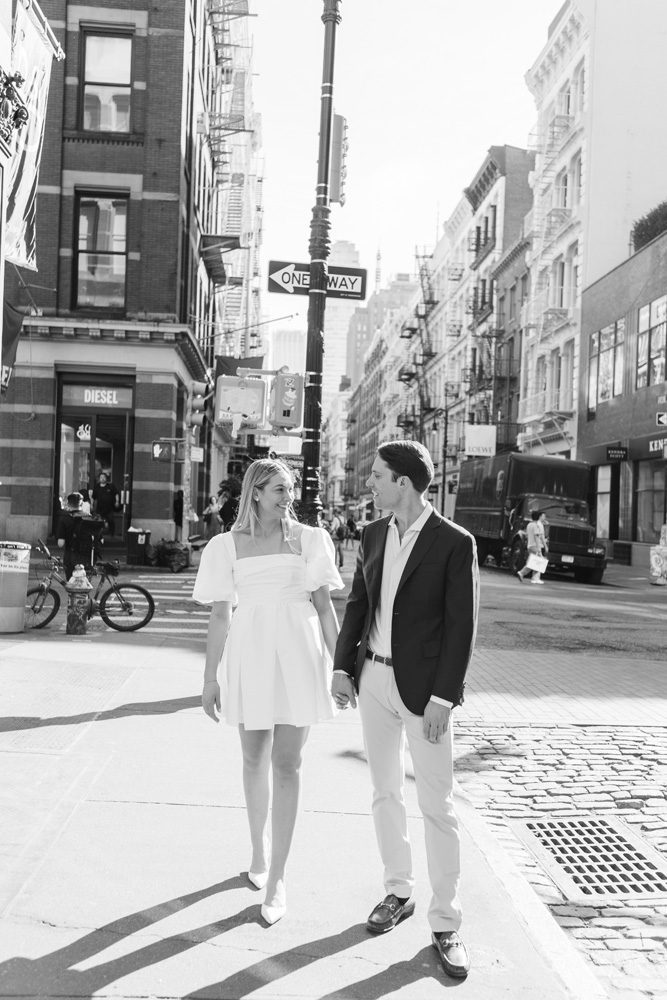 Black and white image of a couple standing on the street