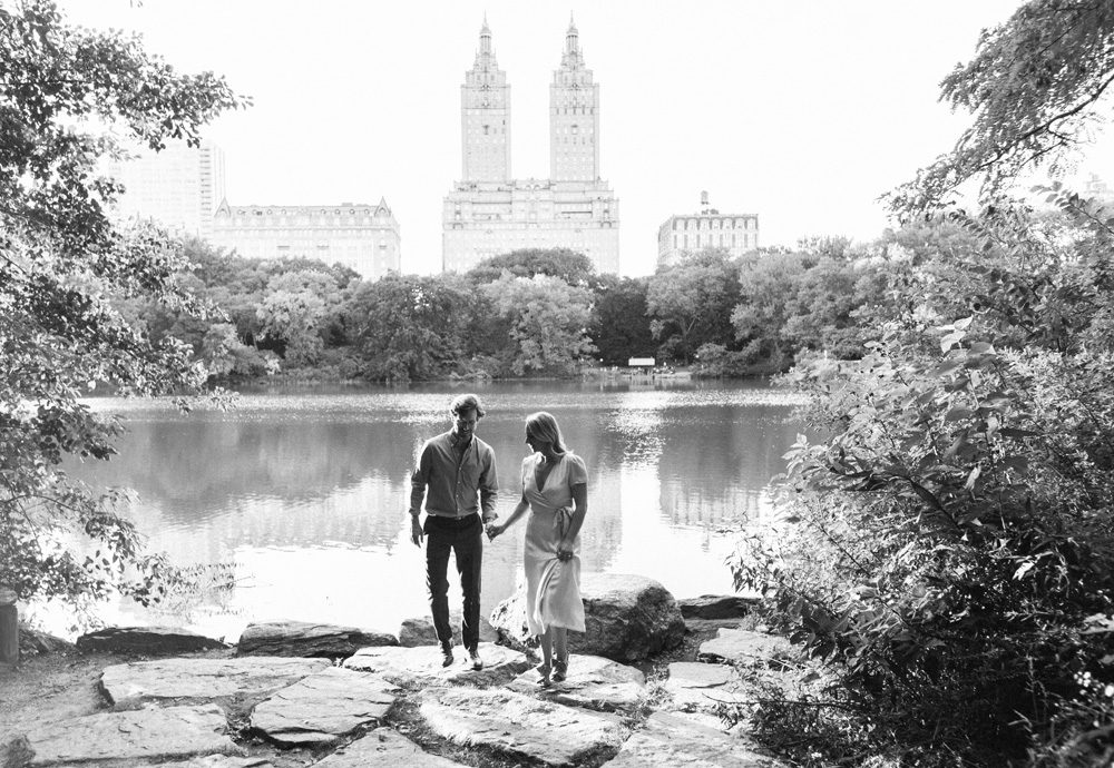 Black and white image of a couple walking near lakes